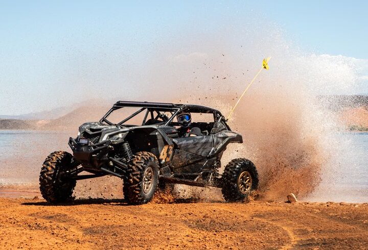 Dune buggy driving through Dubai desert sands under clear blue sky – off-road adventure