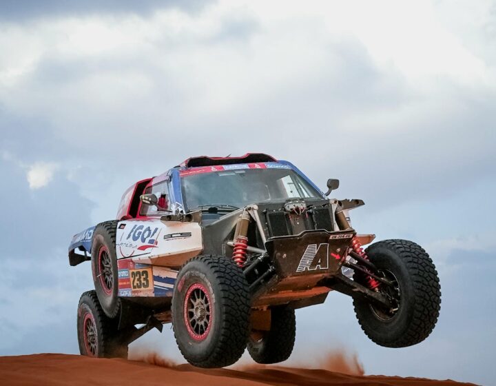 Dune buggy driving through Dubai desert sands under clear blue sky – off-road adventure