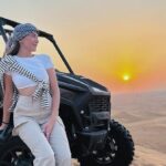 Dune buggy driving through sand dunes in Dubai under clear skies