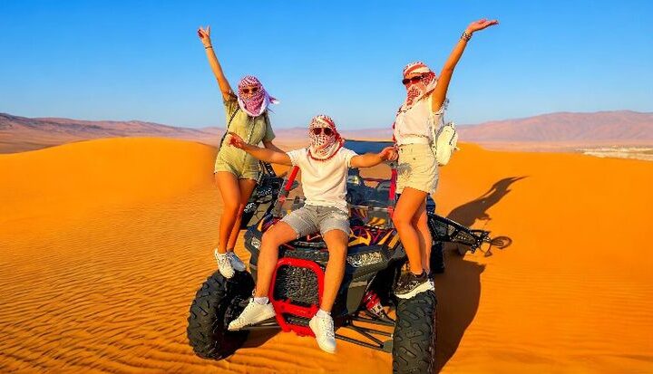 Person enjoying a dune buggy ride in the Dubai desert during vacation