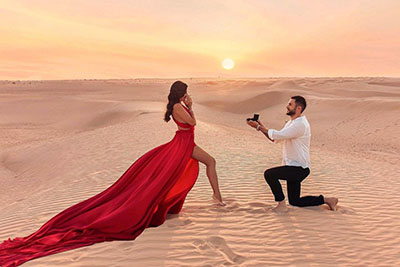 Surprise Engagement Proposal at romantic sunset view of red dunes desert