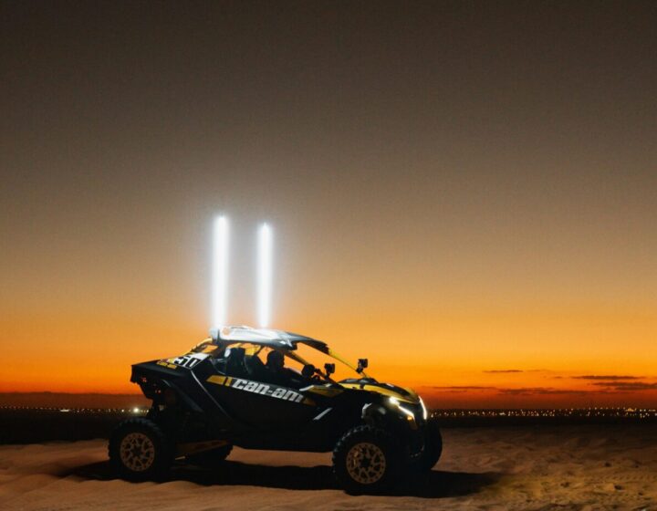 Dune buggy racing through the Dubai desert with golden sand dunes in the background